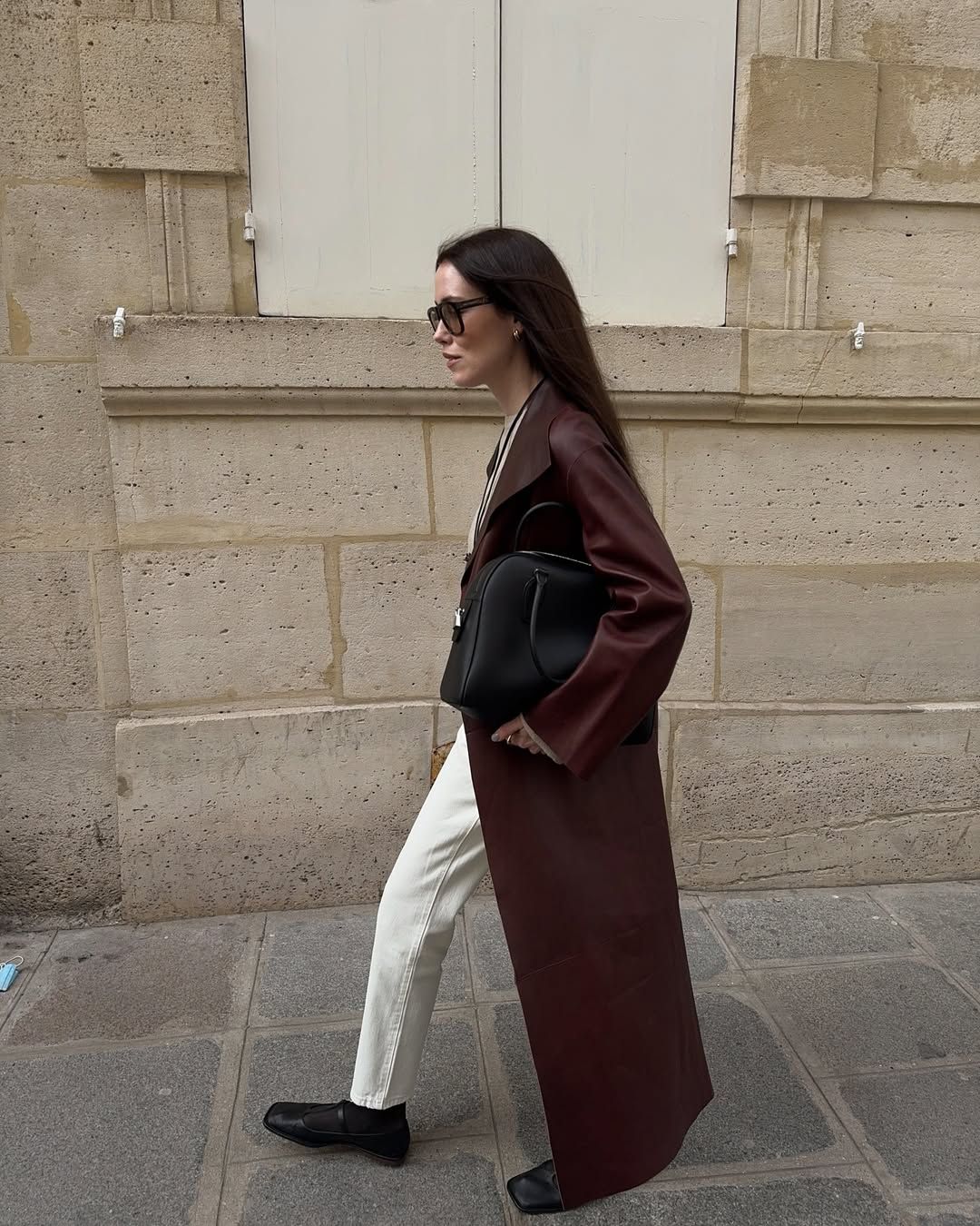 Annabel in a wine-coloured trench, white jeans and black Mary Janes