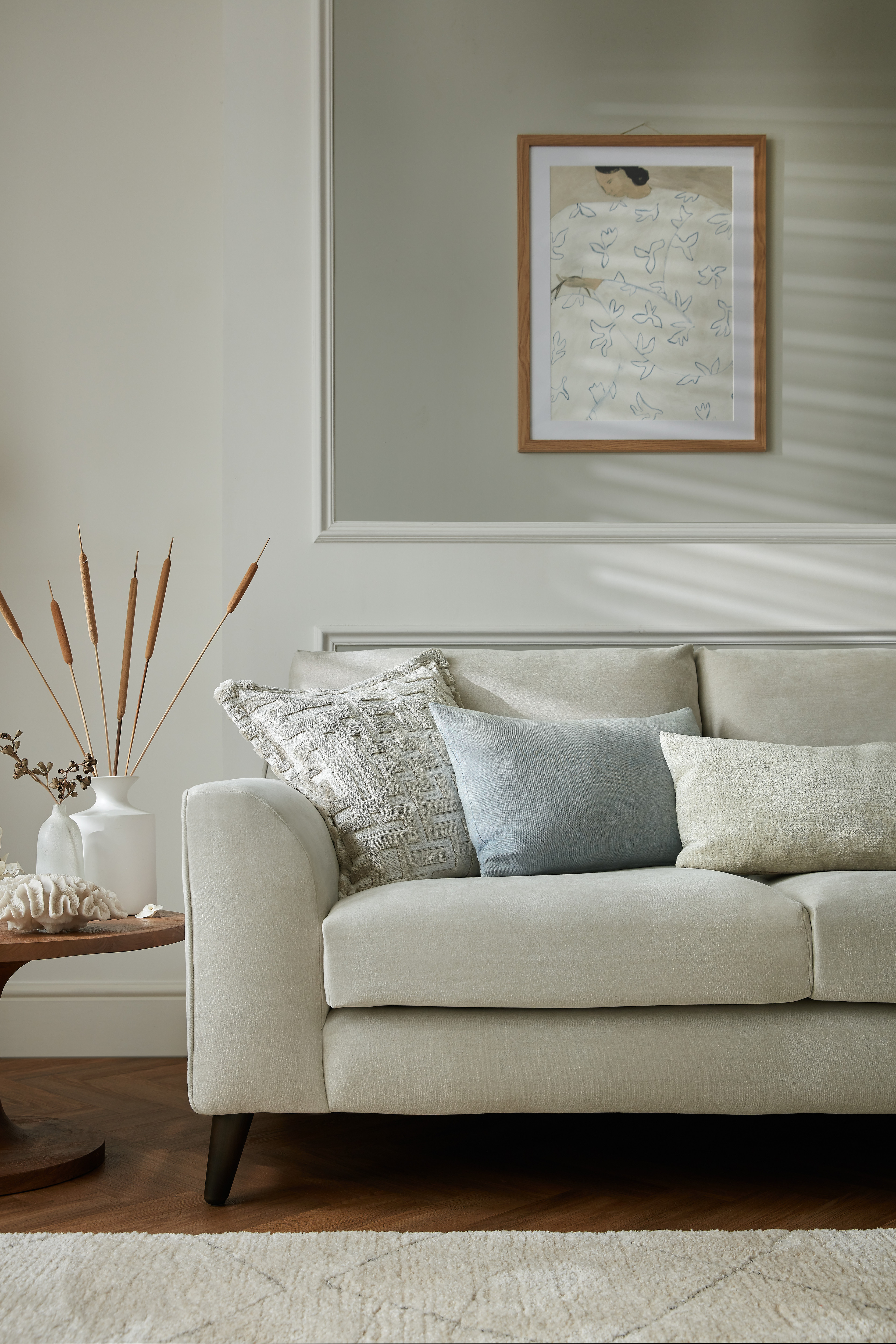 a white sofa in a room with white walls and a grey accent frame
