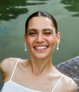 woman smiling and wearing pearl earrings
