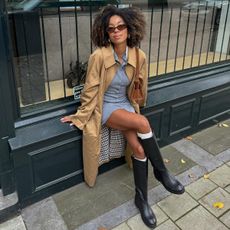 Influencer wearing a trench coat and knee boots