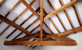 Timber beams in a home with a white ceiling