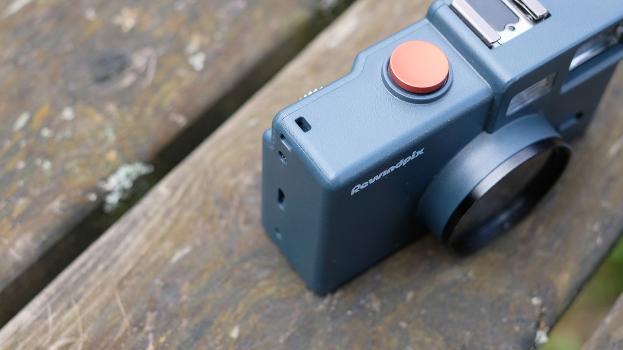 Photograph of RewindPix digital compact camera showing top corner with eyelets for attaching a strap