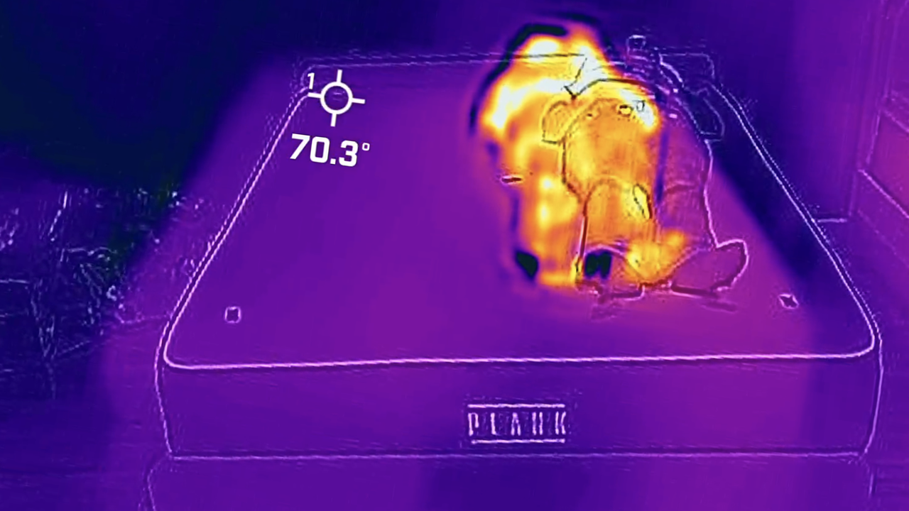 An image taken through a thermal cam, showing sleep writer Frances Daniels lying on the Plank Firm Luxe mattress, extra firm side. While the rest of the mattress is purple, indicating a cooler feel, Frances is a stark orange/yellow, showing the hottest part of the room.