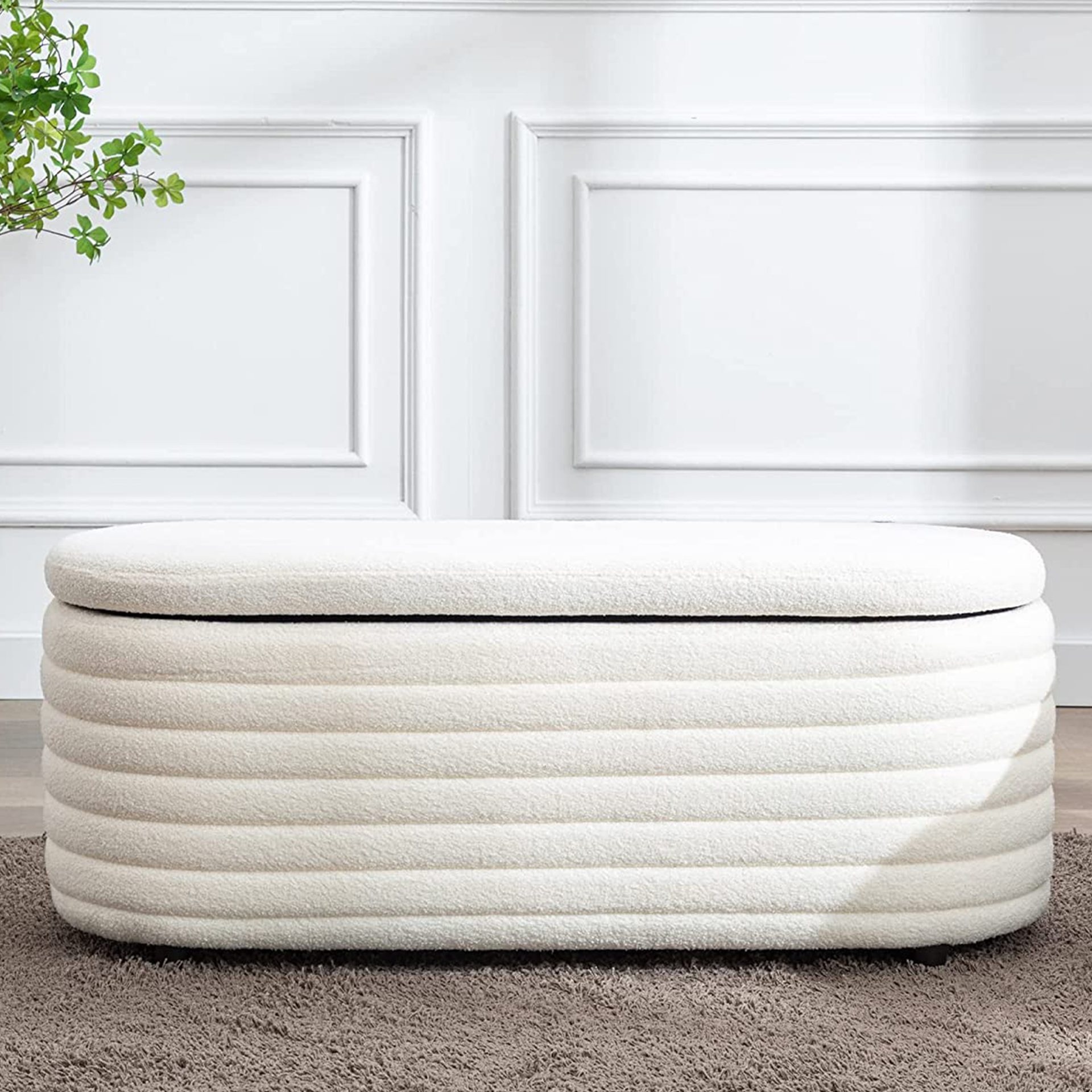 Sebuah bouclé ottoman berusuk berwarna krem berbentuk oval