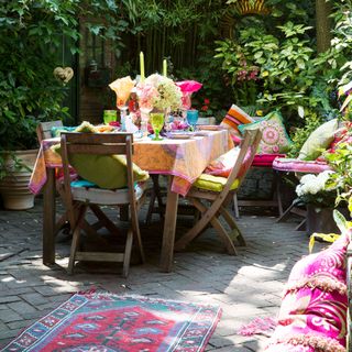 garden with table rug cushion and candles