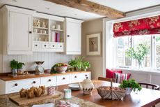 kitchen-with-white-cabinets-red-blinds-and-large-central-island