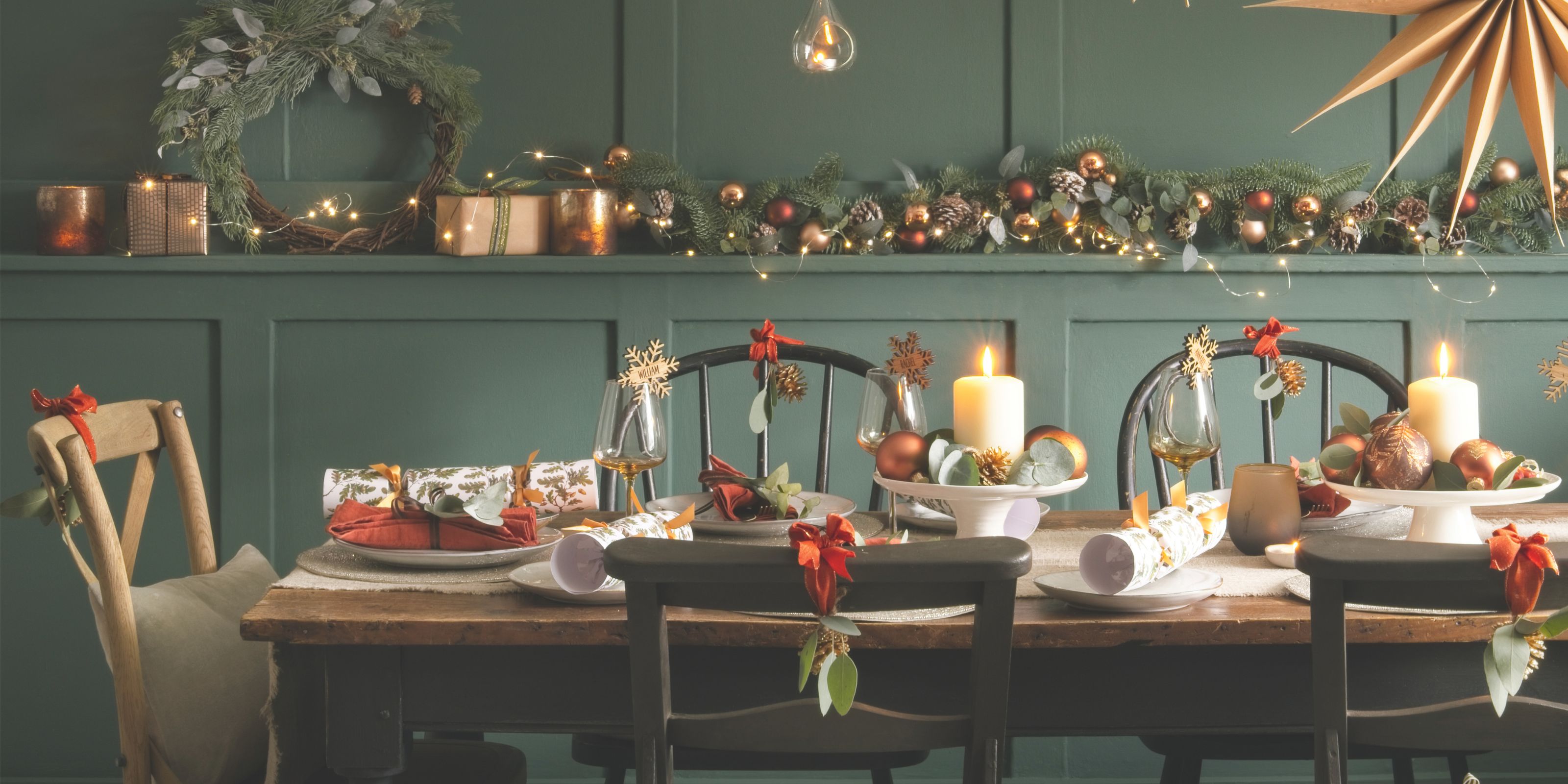A Christmas tablescape with red and white accents against a sage wall