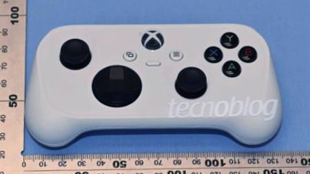 Leaked image of white compact Xbox controller next to square ruler sitting on blue surface.