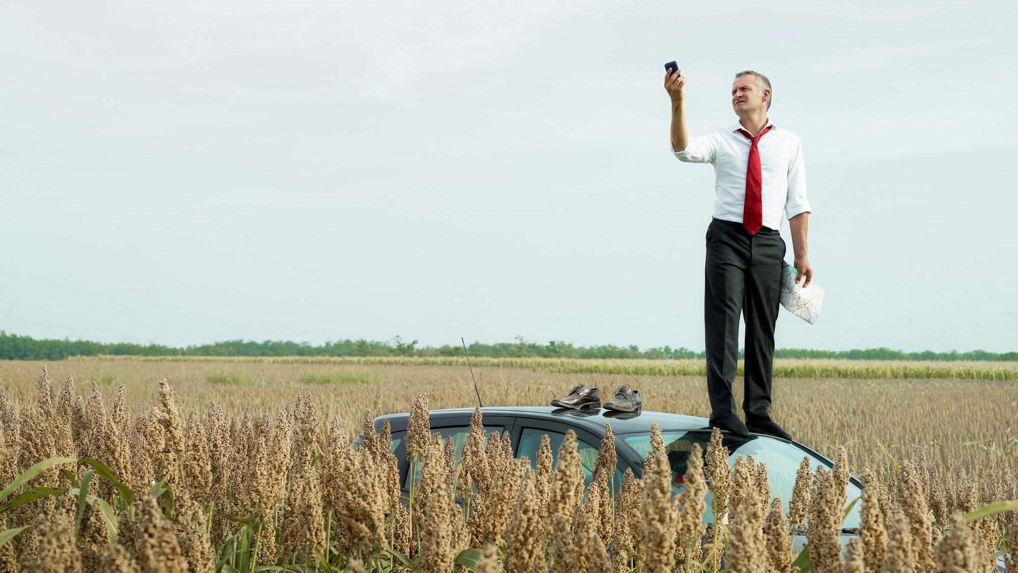 VoIP phone user stands on car for network signal