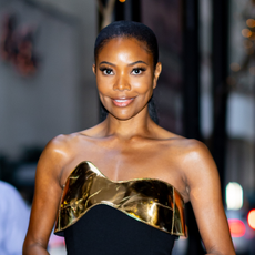 Gabrielle Union smiling at a camera and wearing a high ponytail.