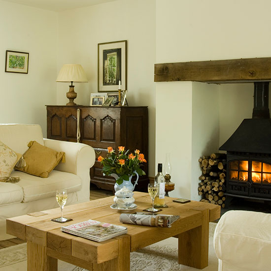 living room with wooden table and fireplace with flower jug