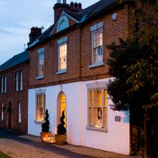 red brick wall house with white window and roof