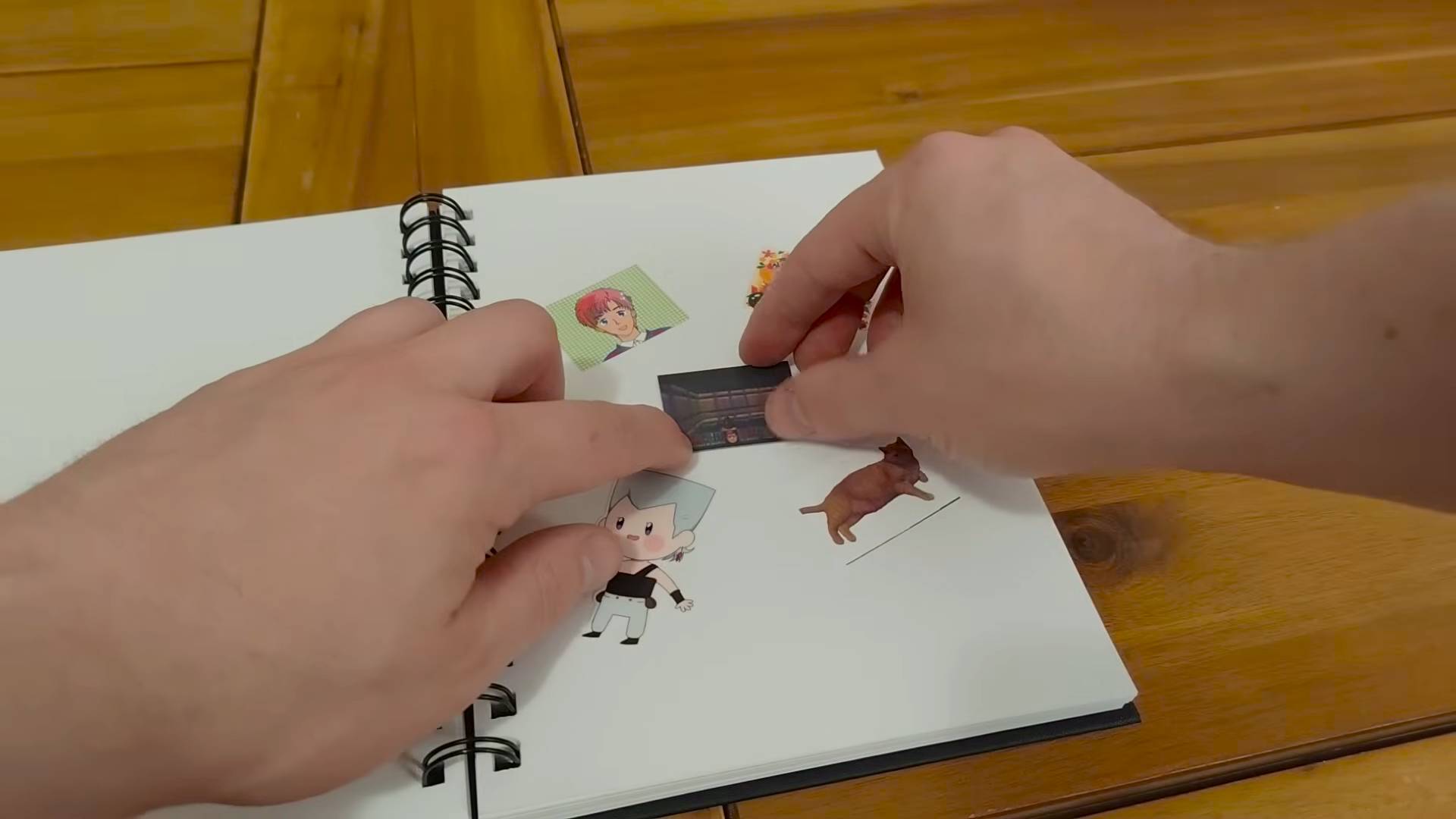 Hands sticking a screenshot sticker of DOOM Casio Loopy port into a notebook surrounded by anime and chibi stickers.