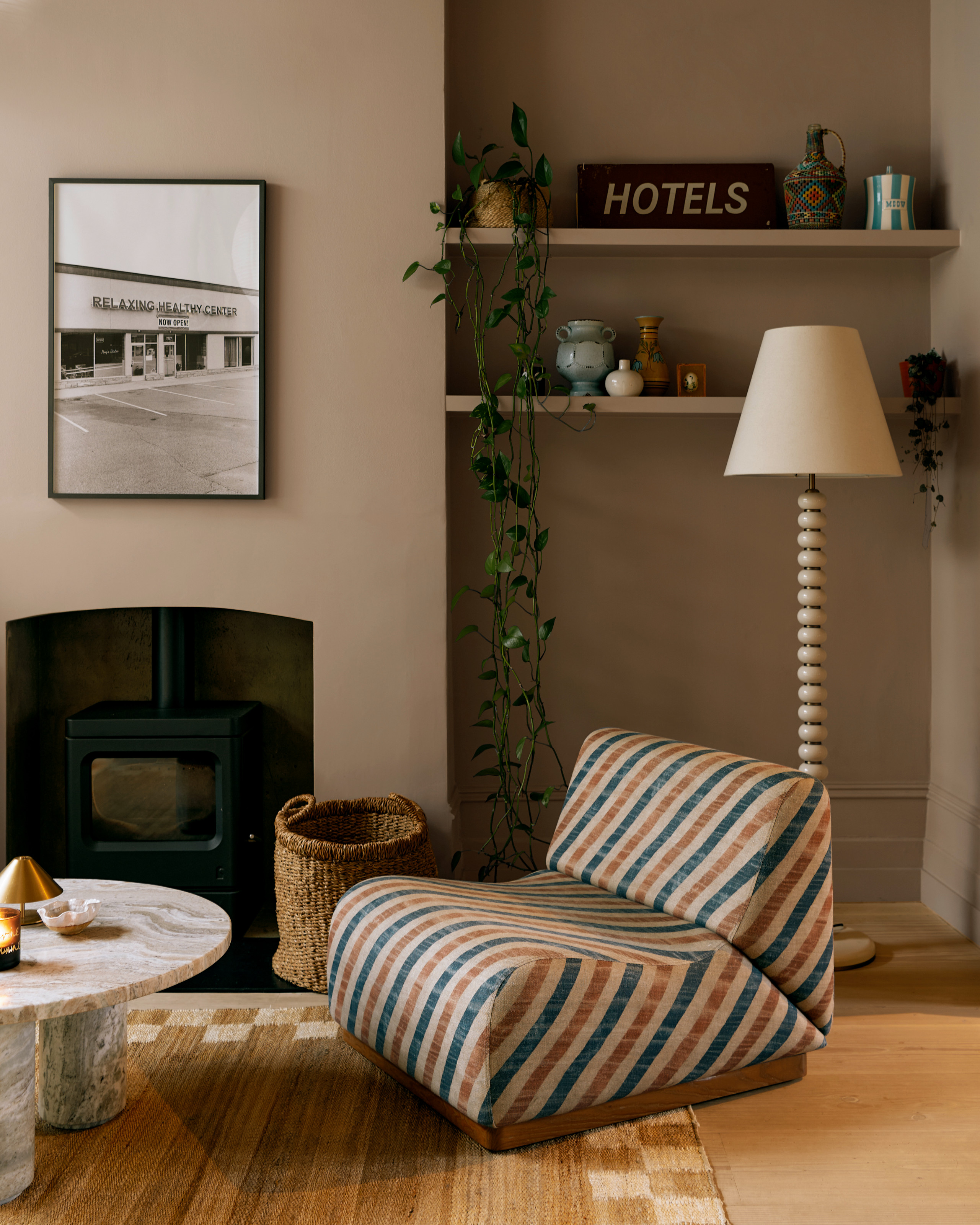 Living room with soft beige walls, striped accent chair and bobbin floor lamp