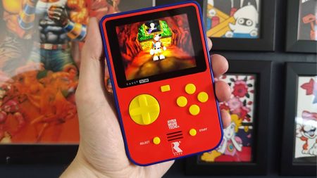 Hand holding Super Pocket with Banjo-Kazooie gameplay on screen.