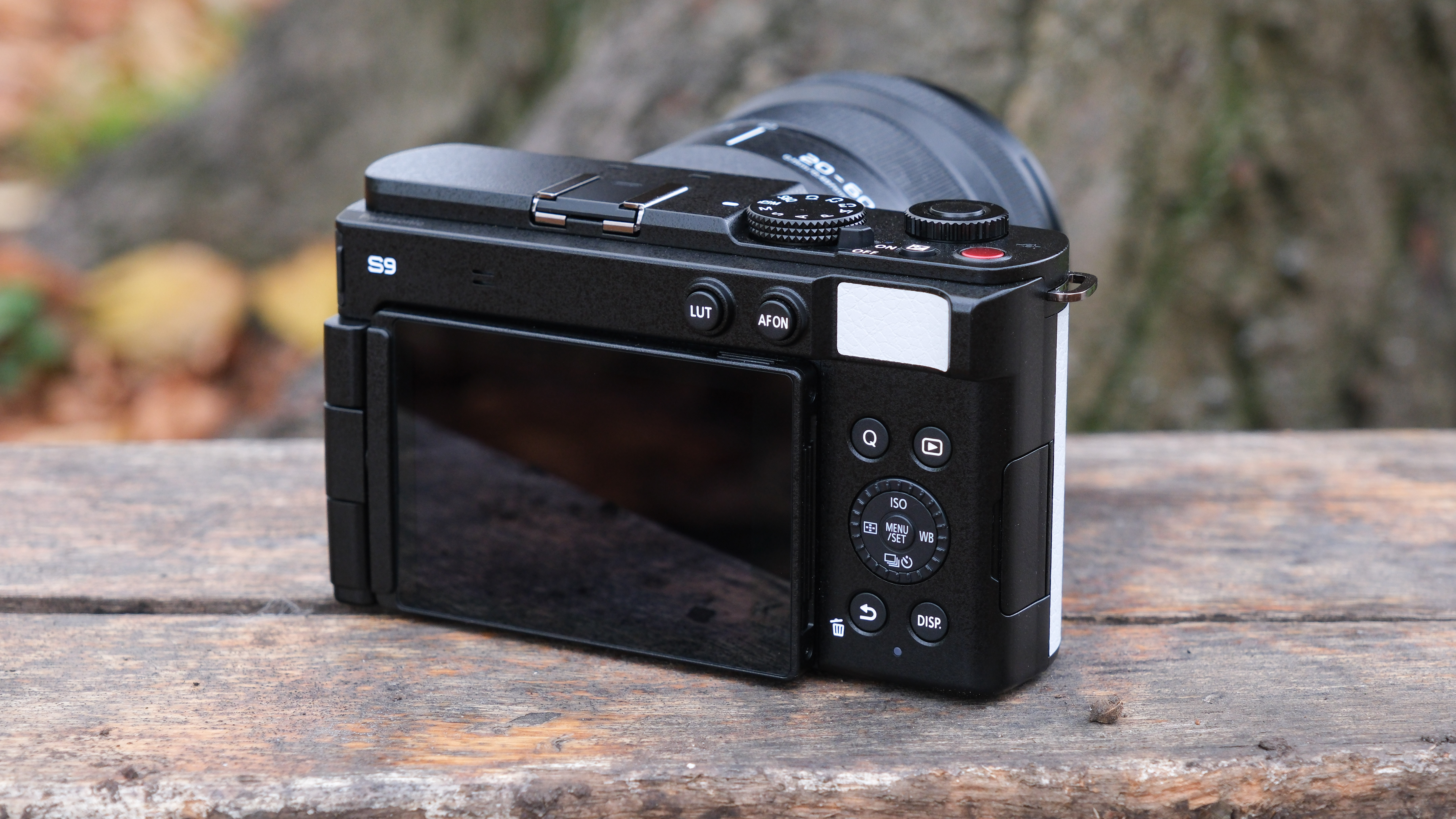 Panasonic Lumix S9 camera in white outside on a wooden bench in front of a tree