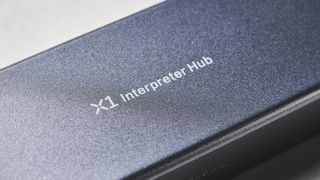 A black and gray Timekettle X1 AI Interpreter Hub translator