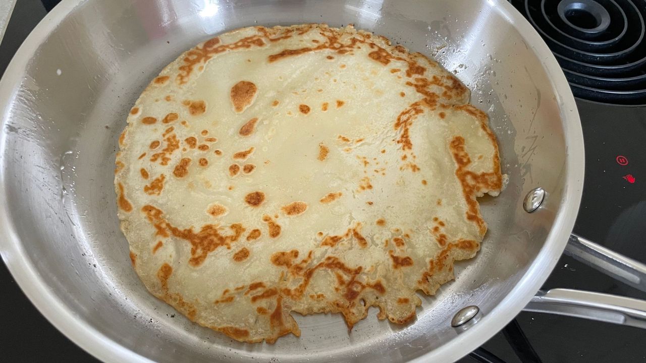 The Le Creuset 3-Ply Stainless Steel Non-Stick Frying Pan making a pancake