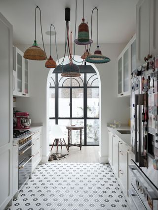 Small white galley kitchen with hexagonal floor tiles