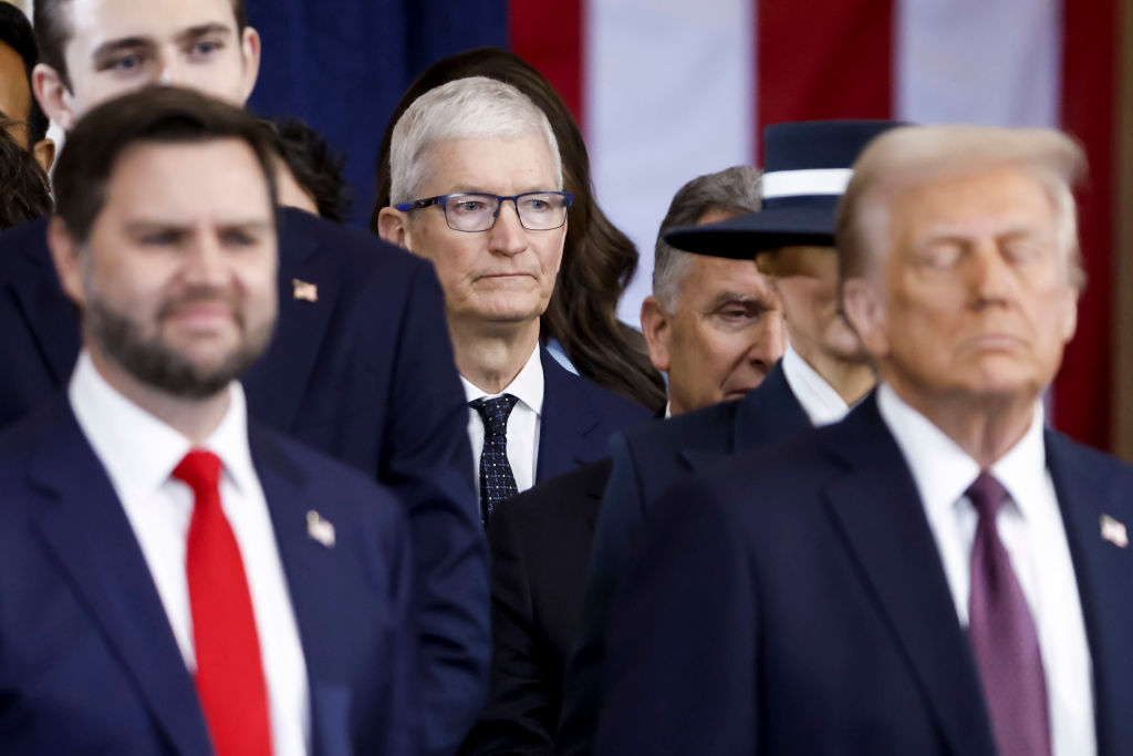 Apple CEO Tim Cook (C) seen behind US President Donald Trump (R) and US Vice President JD Vance (L) after the two were sworn into office at an inauguration ceremony in the rotunda of the United States Capitol on January 20, 2025 in Washington, DC. 