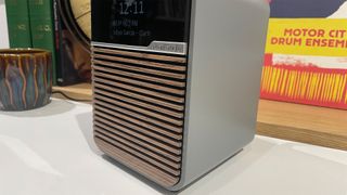 Ruark Audio R1S DAB radio on white shelf showing slatted wooden front