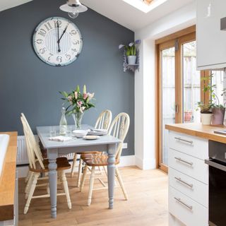 grey dining room with feature wall, painted table and cream chairs