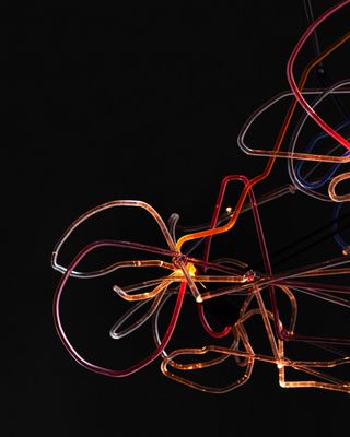 Abstract light consisting of illuminated glass rods which are twisted and curvy