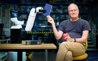 Royal Institution Christmas Lectures host Michael Wooldridge with a robot 