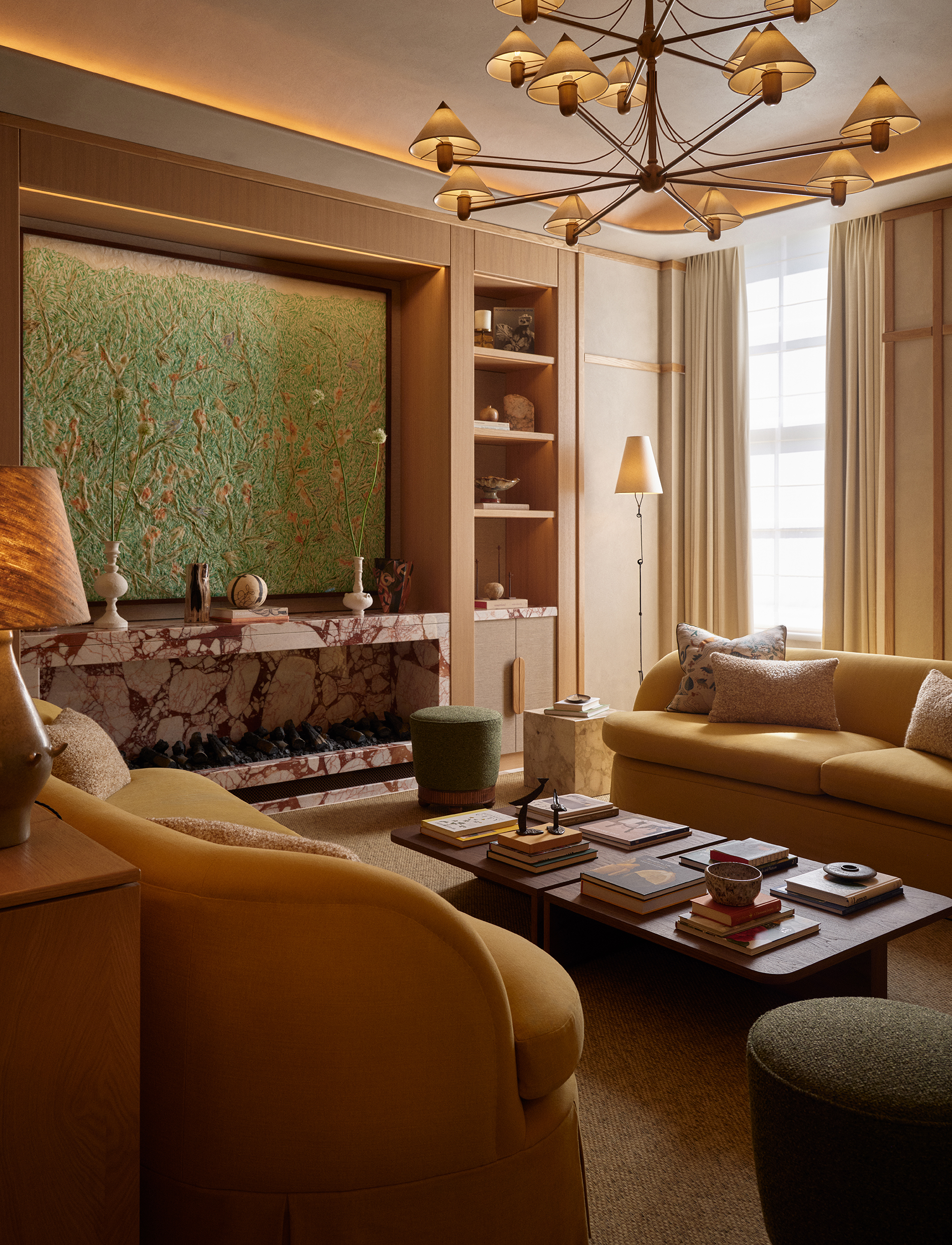 A living room with yellow couches and a vintage chandelier