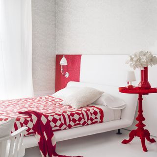 white bedroom with red accessories
