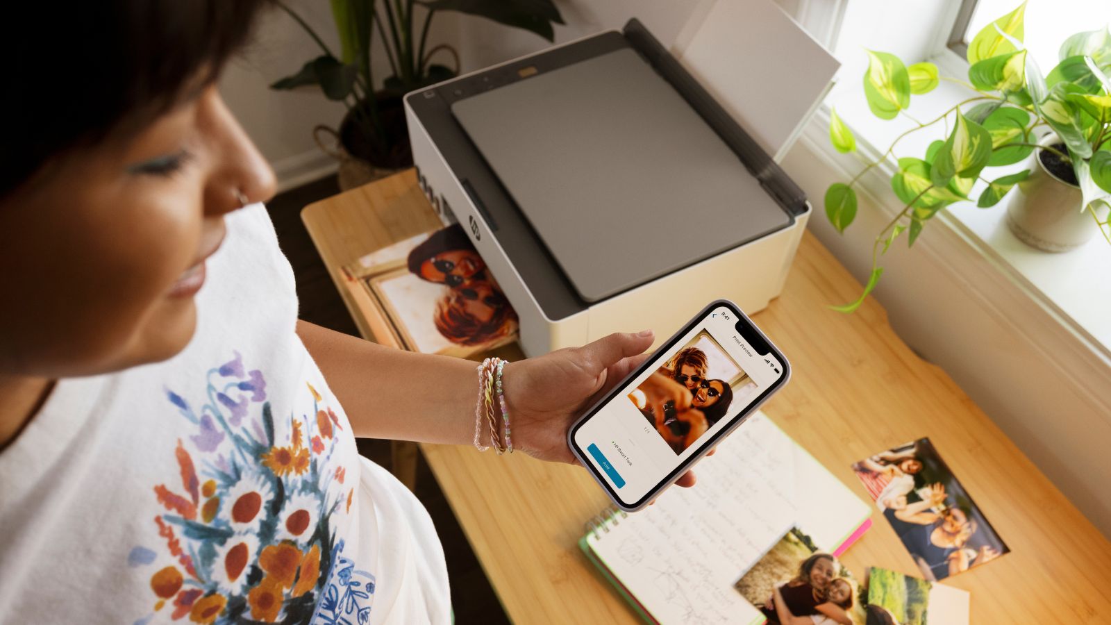 A woman uses the HP Smart app to print from a HP Smart Tank printer.