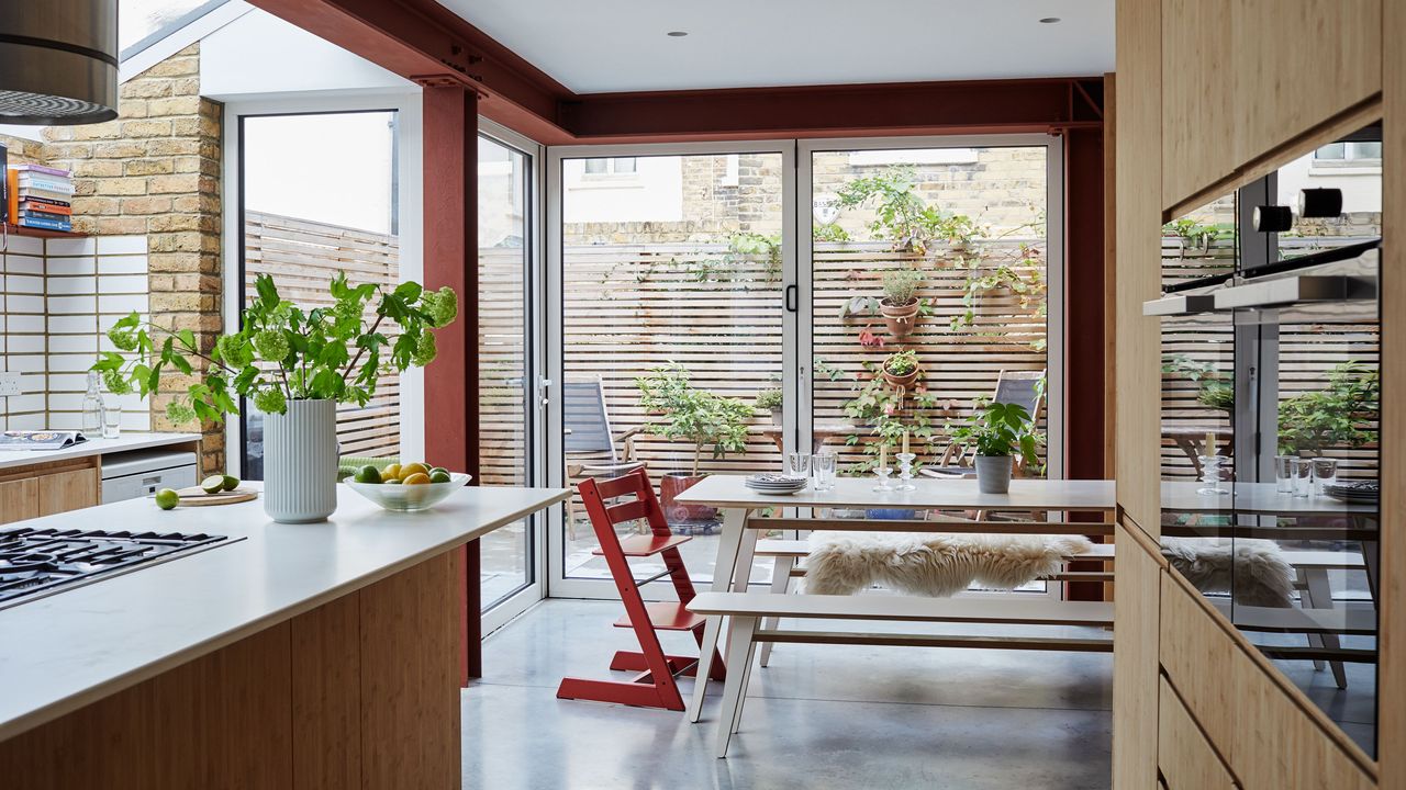 redesigned Victorian home neutral kitchen diner with dining area overlooking bifold doors