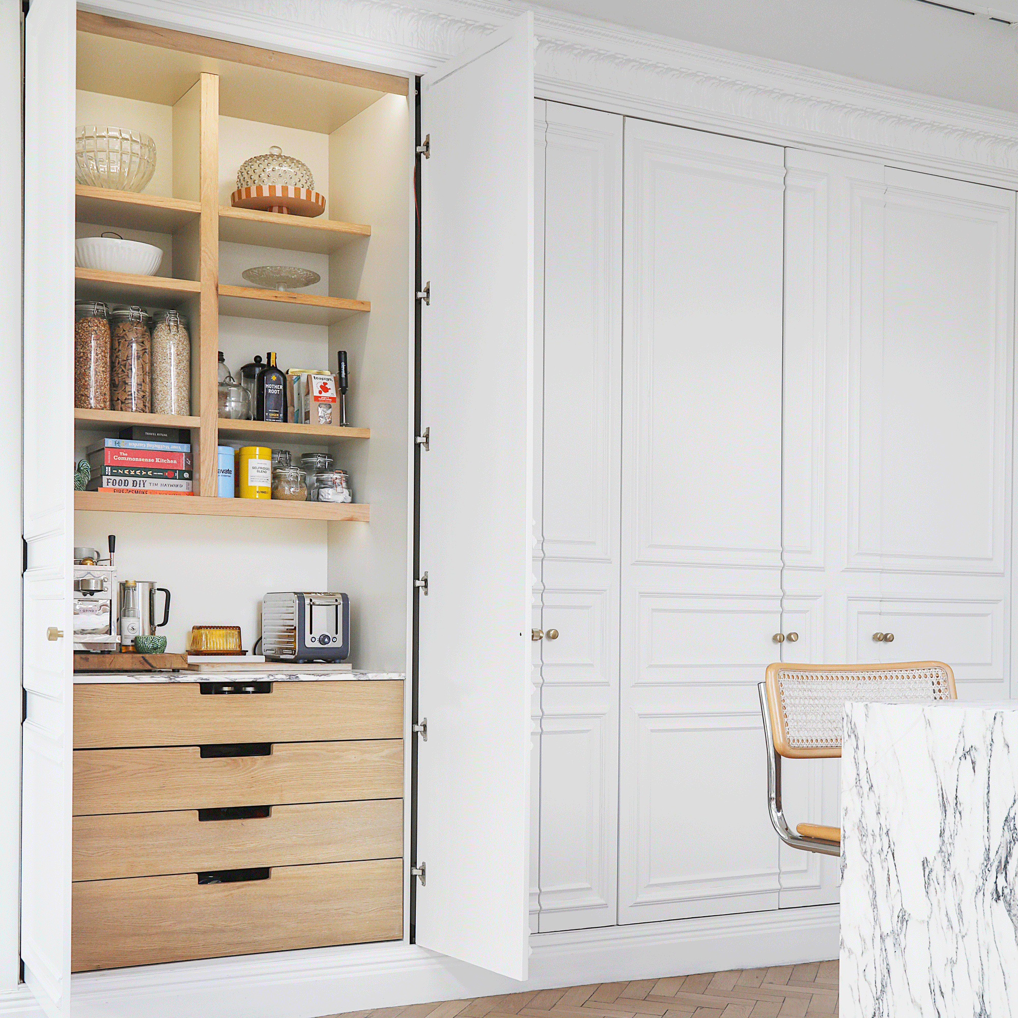 a kitchen with floor to ceiling kitchen cabinets with a pantry and a marble topped kitchen island