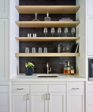 home bar with white cabinets black wall and sink