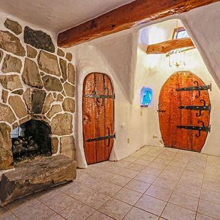 room with stone walls wooden door and tiled flooring