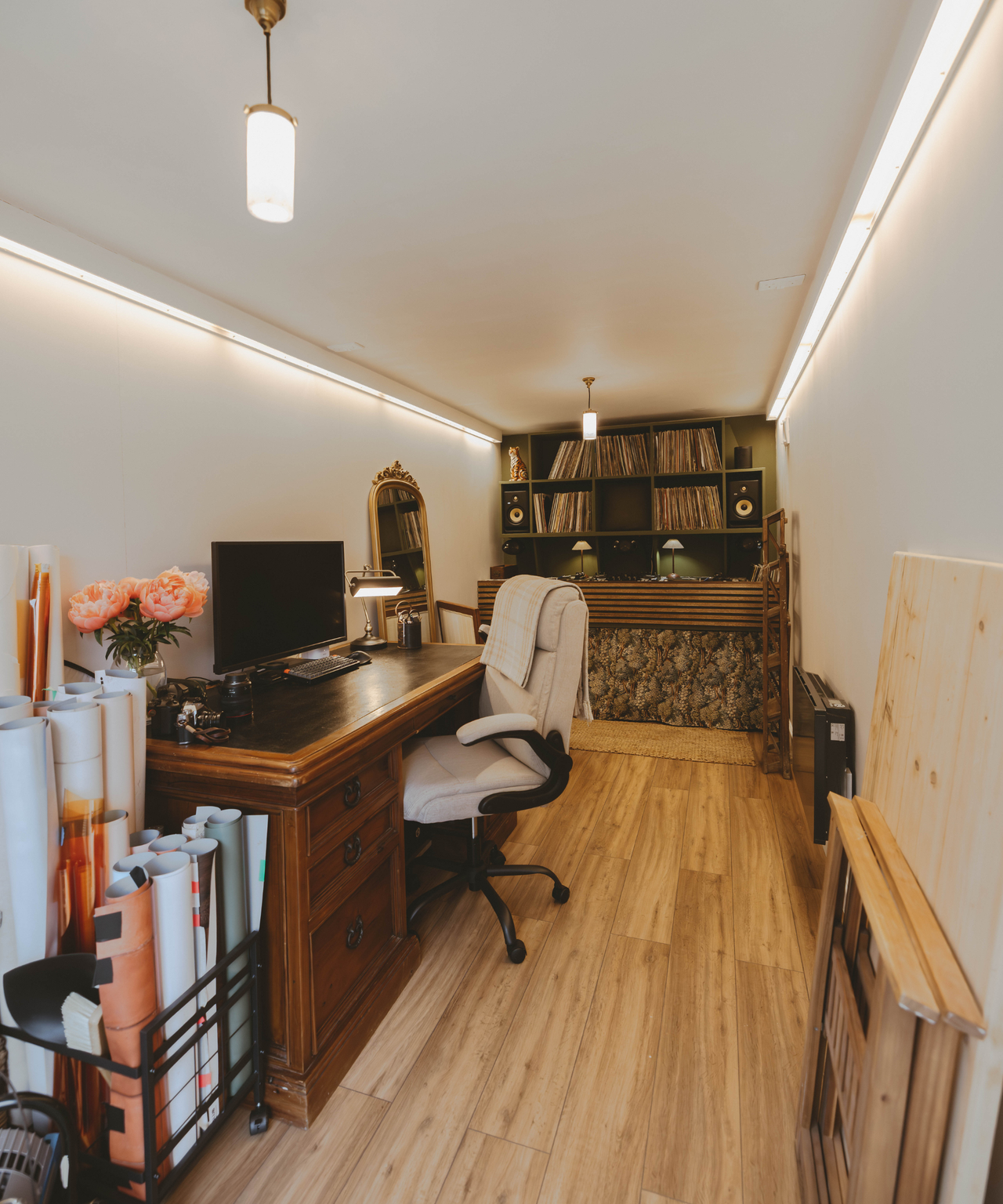 Inside the shipping container with a desk on the right and dj deck set up at the far end