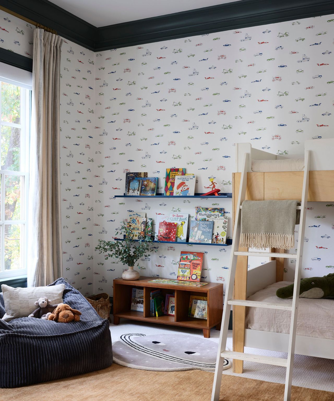 A white kid's room with patterned wallpaper, bunkbeds and a blue bean bag chair