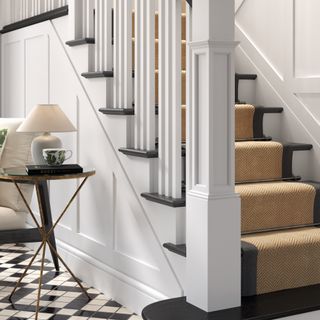 Staircase with white bannister and stair runner
