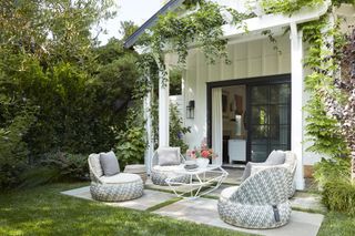 A backyard with low seating chairs and a coffee table