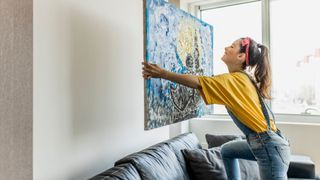 Woman hanging a painting