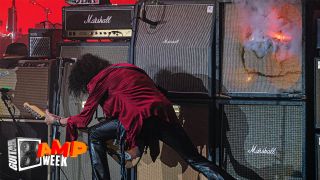 Joe Perry plays guitar in front of massive bank of Marshall amps