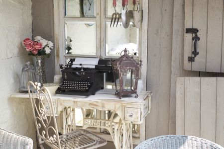 Butlers sink with gold taps, herbs and roses in window and vintage mugs