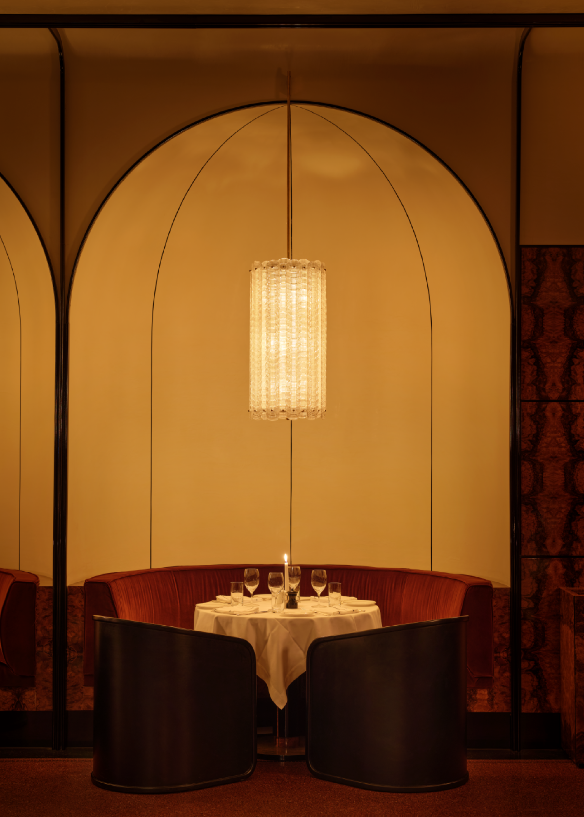 Dining booth in a curved enclave in the wall, with red velvet seats