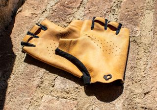 A pair of Pearl Izumi Pro Air mitts on a brick wall