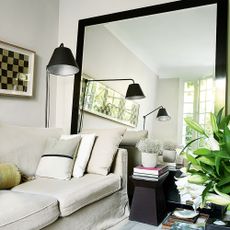 White living room with large floor to ceiling mirror