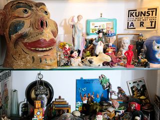 an assortment of different objects including figurines and signs displayed on shelving