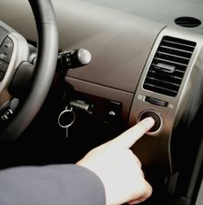 TOKYO, SEPTEMBER 1, 2003:A member of the press touches the ignition button of the Toyota Prius Hybrid car at a press conference in Tokyo. Toyota announce the all new Prius Hybrid car that com