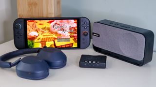 Switch 2 next to some Sony WH-1000XM5 headphones, a DAC, and a Bluetooth speaker