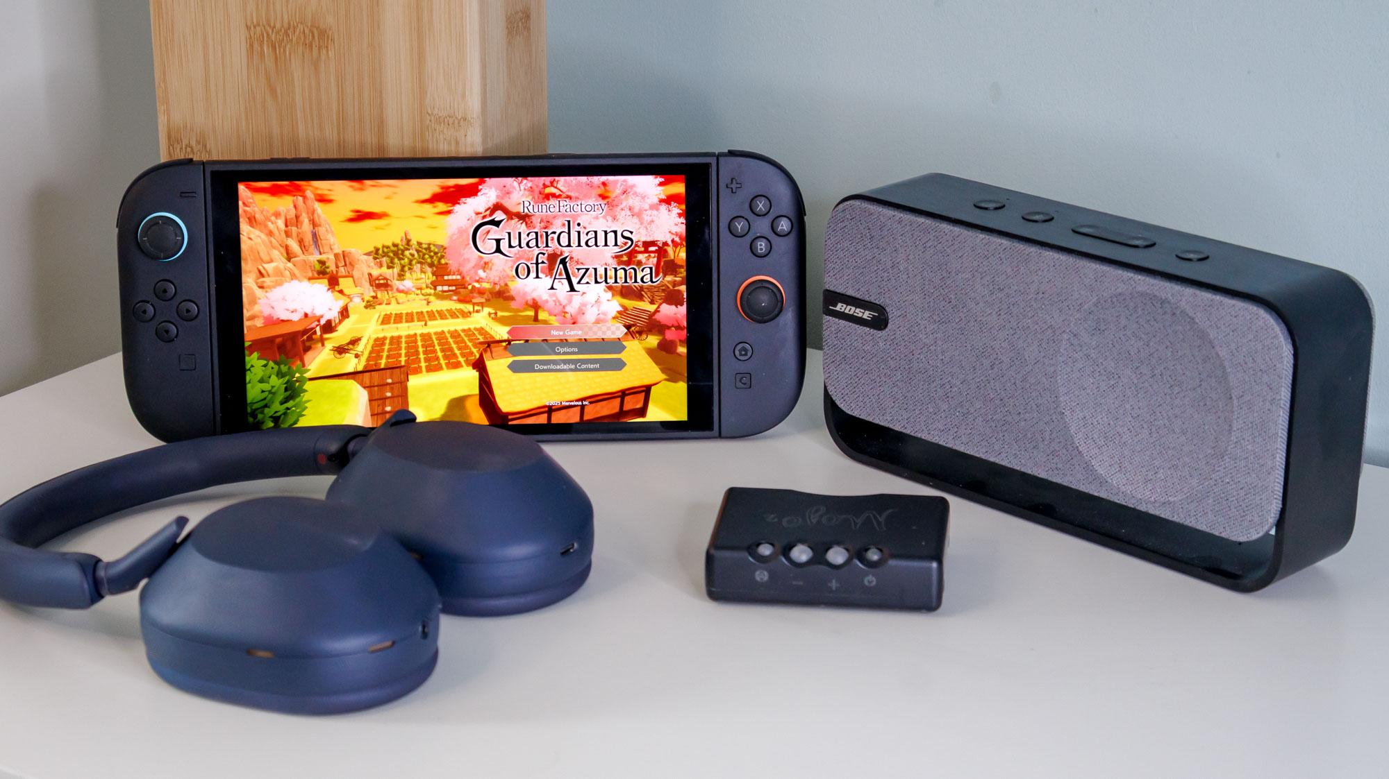 Switch 2 next to some Sony WH-1000XM5 headphones, a DAC, and a Bluetooth speaker