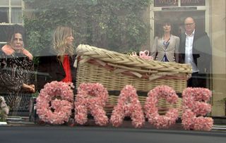Paddy Kirk and Chas Dingle look on as their baby daughter's tiny coffin, adorned with flowers, draws up outside the Woolpack